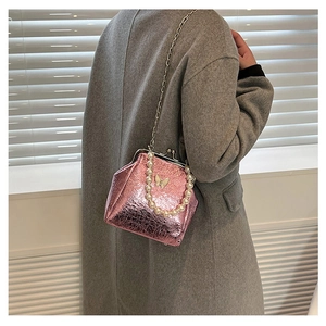 Pink metallic mini crossbody bag with pearl handle and butterfly detail on wool coat