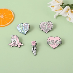 Detailed set of pink skull and rose enamel pins with heart and letter graphics