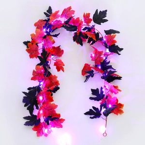 Close-up of autumn maple leaf LED string lights with red and black leaves and glowing bulbs