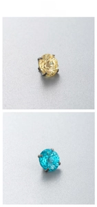 Macro detail of blue and champagne zircon piercing studs with four-prong settings
