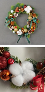 Macro shot of Christmas wreath featuring pine cones, cotton, golden balls, and festive ribbons