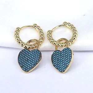 Pair of gold heart hoop earrings with blue pavé zircons on white fabric background
