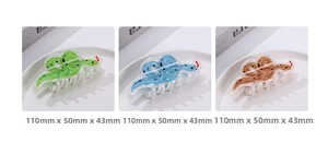 Detail view of 110mm snake-shaped hair claws in green, blue, and brown acrylic patterns