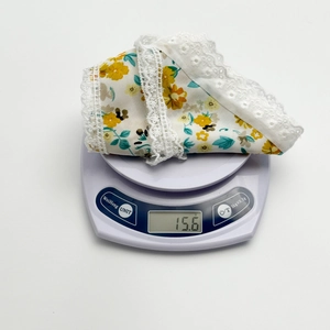 Detail showing the ultra-light 15.6g weight of this lace floral cotton headscarf