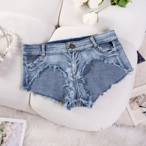 Dettaglio di pantaloncini di denim a vita alta azzurri con orli sfilacciati e strappi vivi