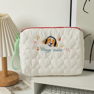 Detailed close-up of a quilted heart-shaped bag with cartoon dog music embroidery