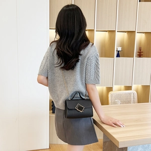 Chic black embossed mini handbag with gold square buckle and chain strap shown on model