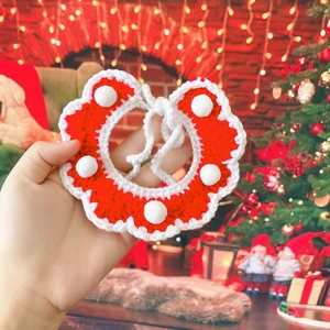 Vue détaillée d'une écharpe de Noël pour animaux tricotée main avec pompons blancs