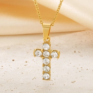 Polished gold cross pendant necklace with six inset clear stones on a textured base