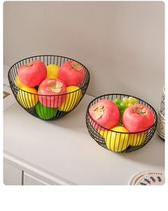 Detail of two black iron wire fruit baskets with minimalist hollow line design in a set