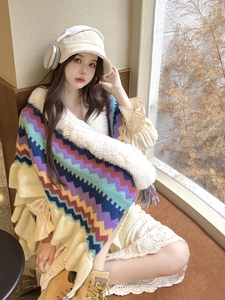 Close-up of bohemian knit shawl with colorful wave patterns and a soft faux fur collar
