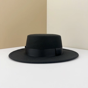 Detail of black flat top wool felt fedora hat featuring a matching grosgrain ribbon band