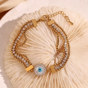 Close-up of triple-layer 18K gold plated bracelet with evil eye and pavé zircon details