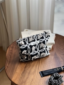 Detail of linen canvas makeup bag with butterfly floral embroidery and zipper closure