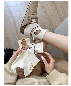 Close-up of cute cartoon bear cotton socks in cream and brown on model feet