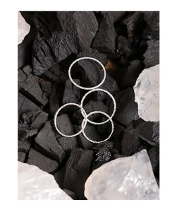 Detailed view of four 925 sterling silver minimalist 1mm rings on dark charcoal background
