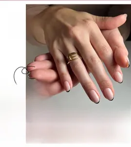 Detail of short French black tip press-on nails with nude pink base on fingers