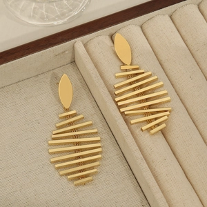 Minimalist 18K gold plated fishbone drop earrings on a beige velvet jewelry display box