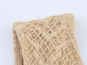 Detailed macro view of the beige hollow knit lace texture and exquisite weaving craft