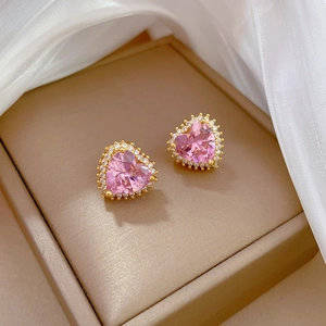 Close-up of heart-shaped pink zircon earrings with gold plating and pavé diamond halo