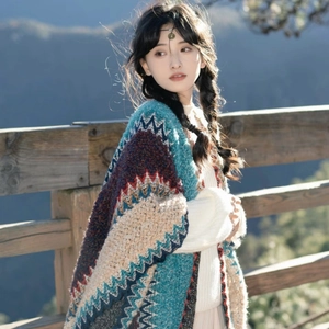 Knitted shawl with ethnic geometric patterns in blue and burgundy on a model outdoors
