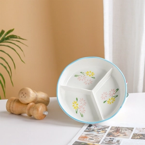Détail d'une assiette en céramique blanche à 3 compartiments avec motifs floraux
