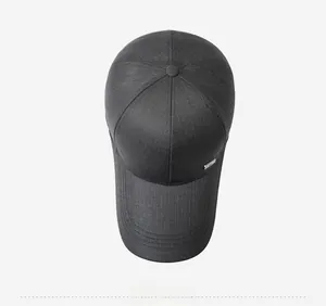 Detail view of dark grey baseball cap showing textured fabric and metal logo accent