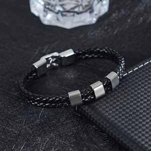 Detail of multi-layer black braided leather cord and brushed stainless steel clasp