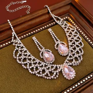 Luxury water drop jewelry set with pink crystals and shimmering diamonds on green velvet