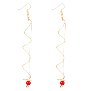 Detail of gold spiral drop earrings featuring elegant red pearls and French hooks