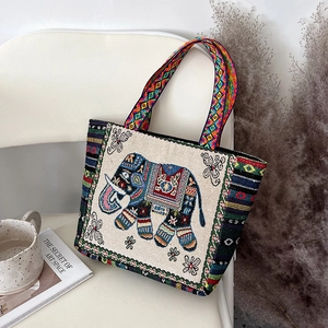 Detailed close-up of colorful ethnic elephant embroidery on beige canvas tote bag