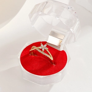 Detail of 18K gold ring with floral zircon and side stones in a red velvet gift box