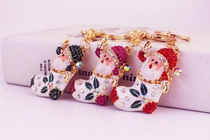 Detailed view of Santa Claus boot keychains with sparkling rhinestones in gold plating