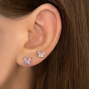 Close-up of butterfly stud earrings with colorful zircons on a model's ear