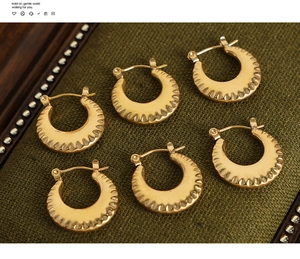 Detailed view of three pairs of vintage gold textured titanium steel hoop earrings
