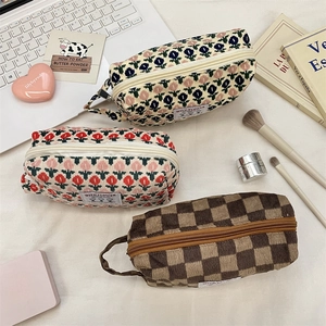 Detailed set of three corduroy cosmetic bags with floral and checkerboard patterns
