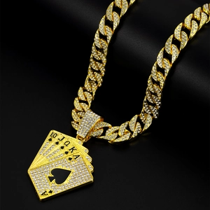 Macro shot of gold-plated iced-out poker cards pendant on a Cuban link chain necklace