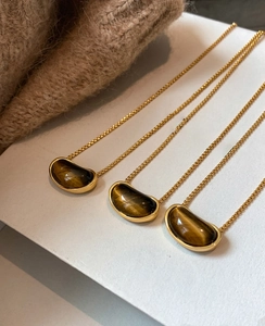 Detailed close-up of 18k gold plated pea-shaped tiger eye stone pendant necklaces