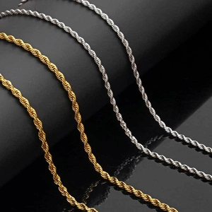 Close-up of gold and silver stainless steel rope chain necklaces on black stand