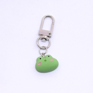 Detailed close-up of a cute green resin frog keychain with a durable silver metal clasp
