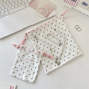 Detailed view of polka dot drawstring storage bags with pearls and pink strings