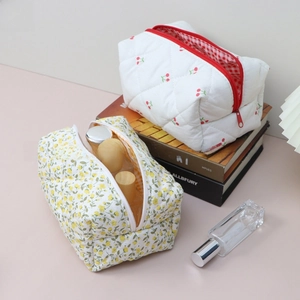 Detailed view of quilted cotton floral cosmetic bags with cherry and flower patterns