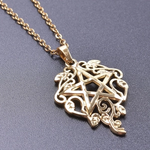 Vue macro du pendentif étoile en acier inoxydable plaqué or 18K avec motifs de fleurs