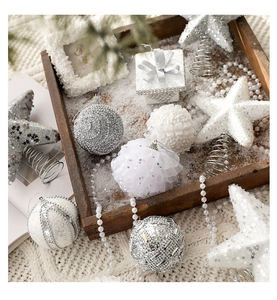 Close-up of white and silver glittery Christmas tree ornaments on a cozy wooden tray