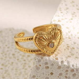 Macro détaillée d'une bague coeur plaquée or 18 carats avec texture radiale et zircon central
