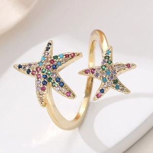 Macro side view of gold starfish ring featuring colorful zircon pavé and adjustable band