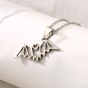 Close-up of a silver geometric origami bat pendant on a stainless steel O-chain necklace