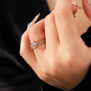 Close-up of a chalcedony resin ring featuring a silver gothic cross on the finger