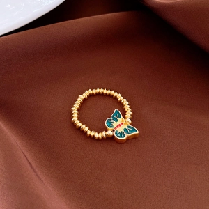Detailed macro view of a vintage gold-plated butterfly ring with colorful enamel inlay work