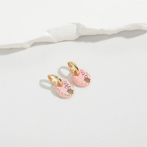 Macro detail of oval pink enamel earrings with gold crackle patterns on a stone base